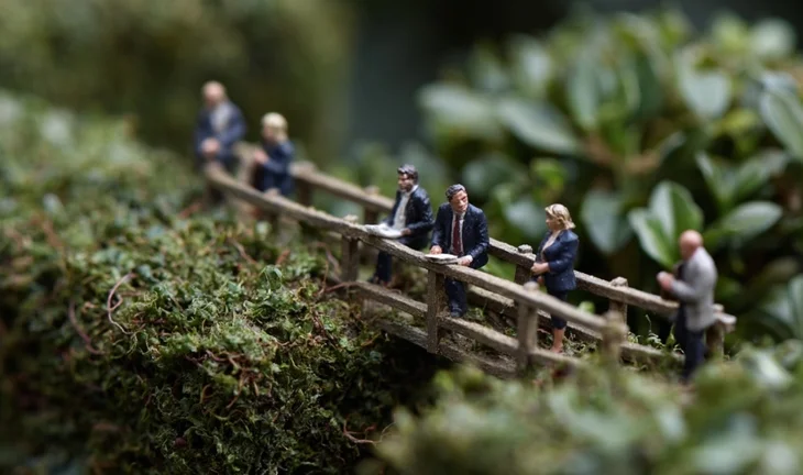 a bridge between hedges with plastic people on it