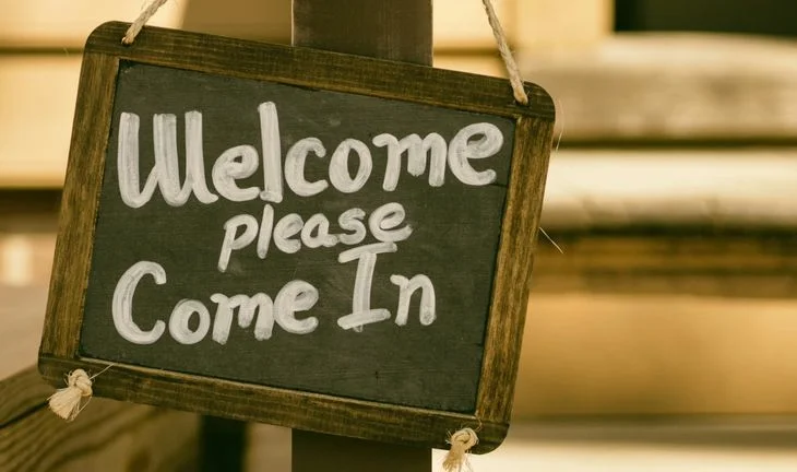 a sign that says welcome please come in 