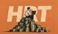 A man with a laptop sitting on a pile of money. Letters 'HRT' in the background